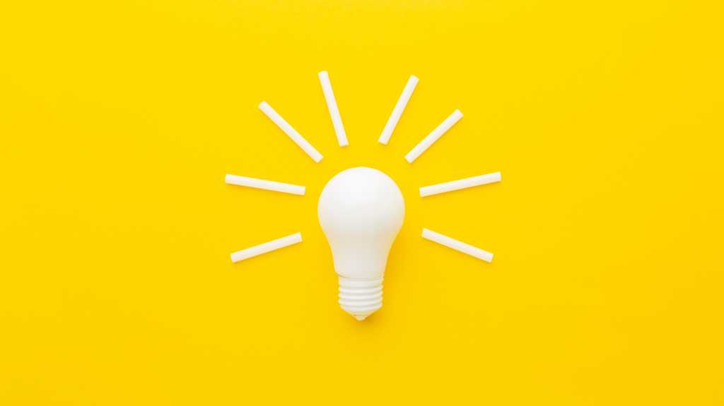 shutterstock 2408848757 white light bulb and white sticks of chalk on bright yellow background