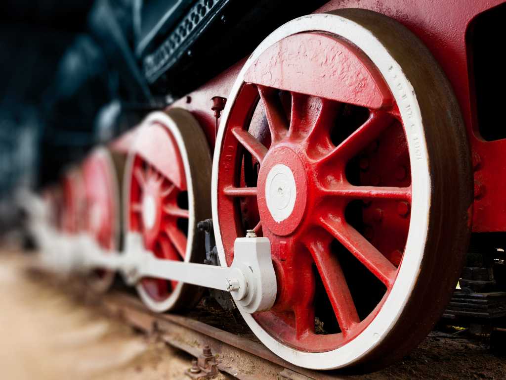 closeup of train wheels on railroad track steam locomotive red wheels with white trim