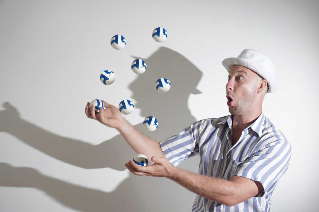 A young man in a white hat and a white and blue striped shirt juggles balls on a white background