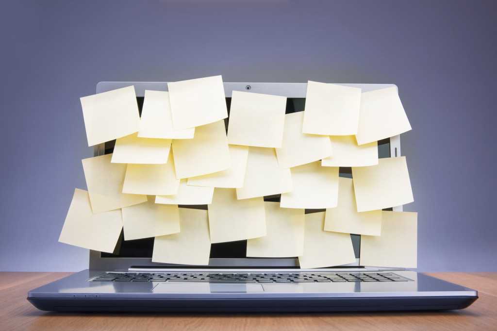 laptop covered with sticky notes