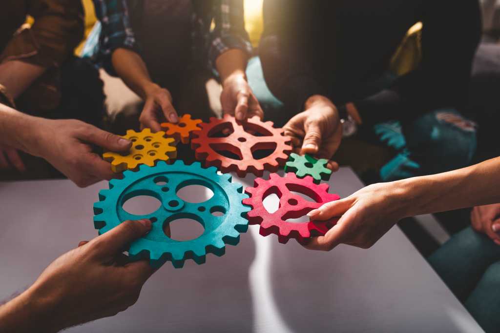 shutterstock 2270669753 teamwork concept team putting colored gears together