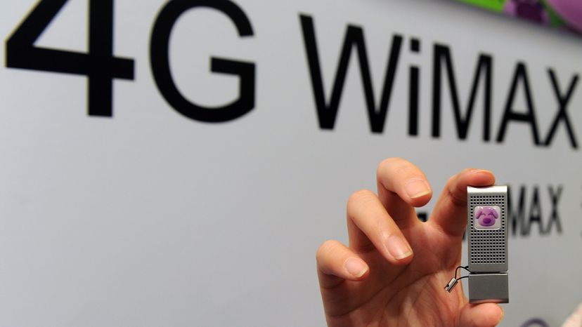 A woman displays a small silver fourth-generation WiMAX device
